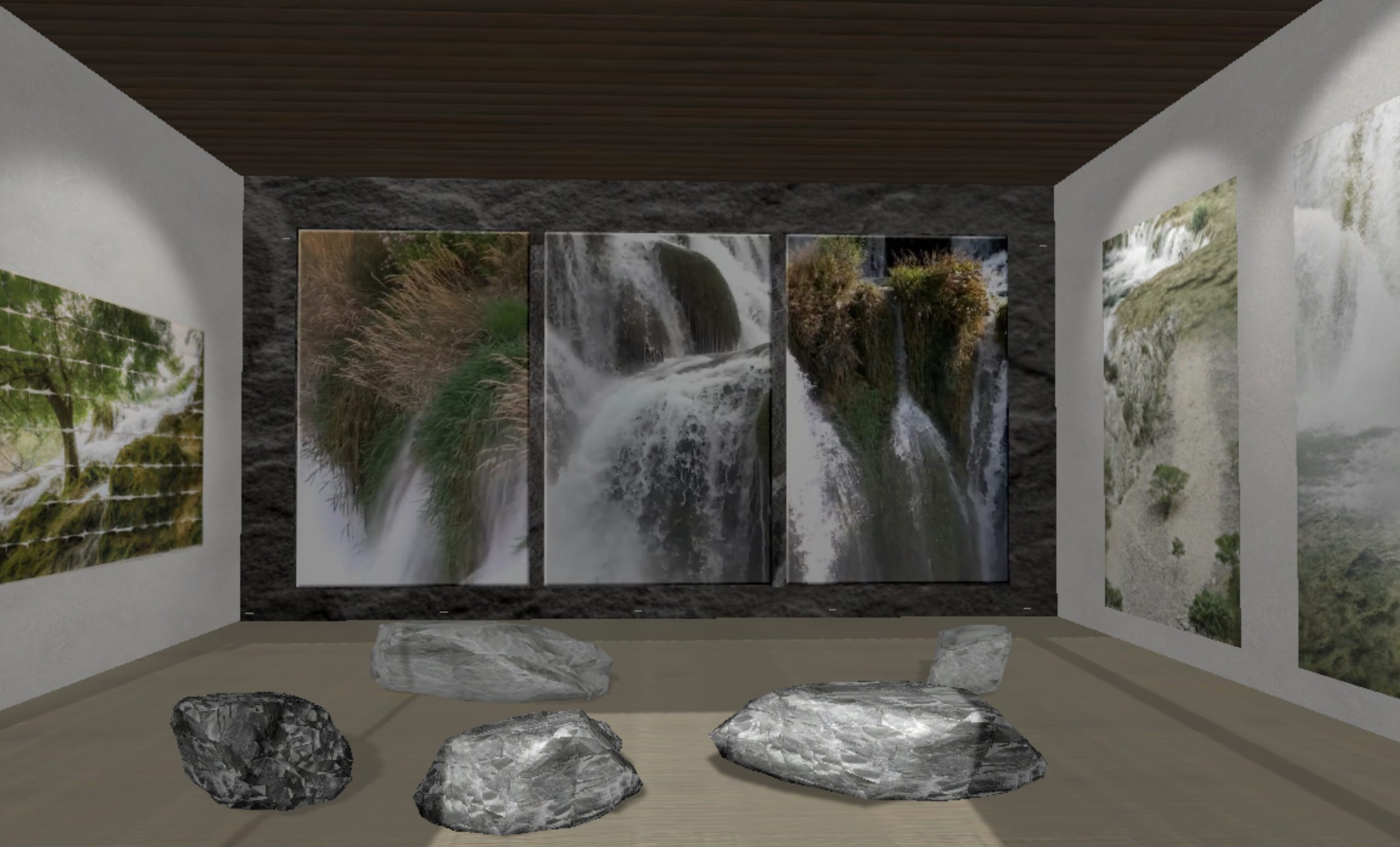 Gallery installation view: projected waterfall panels and river stones on the floor